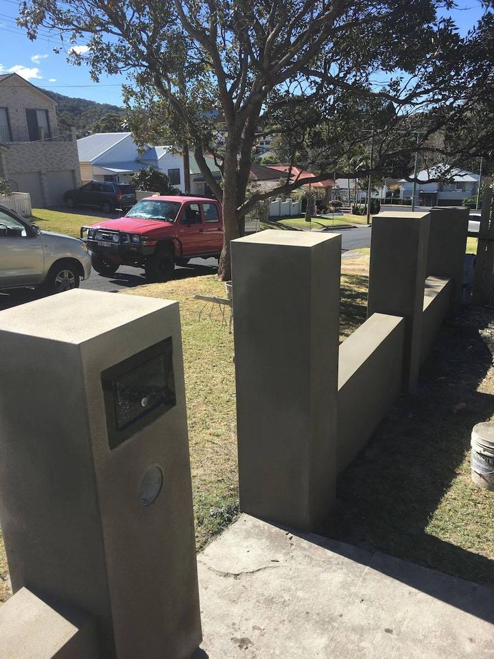A row of rendered front fence piers along a residential street frontage