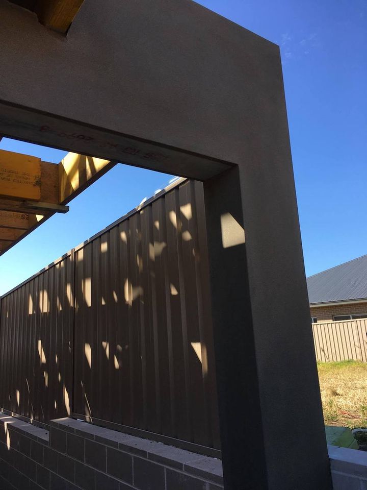 A rendered gate portal framing a colorbond fence, with square corners