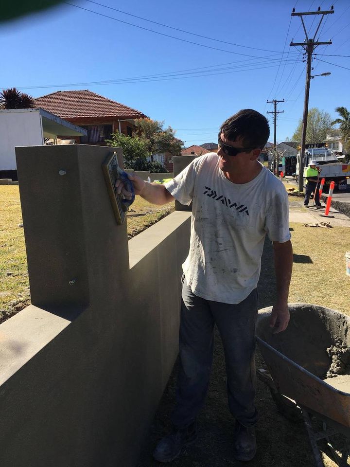 A renderer working the face of a front fence pier on site
